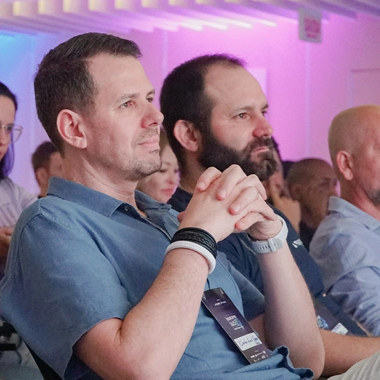 Dois colaboradores da Seprol sentados lado a lado, atentos durante uma apresentação em evento