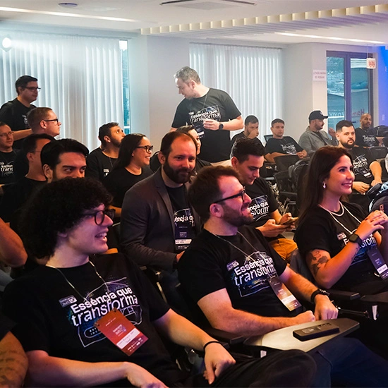 Equipe Seprol reunida em evento, sentados e sorrindo, vestindo camisetas 'Essência que transforma'