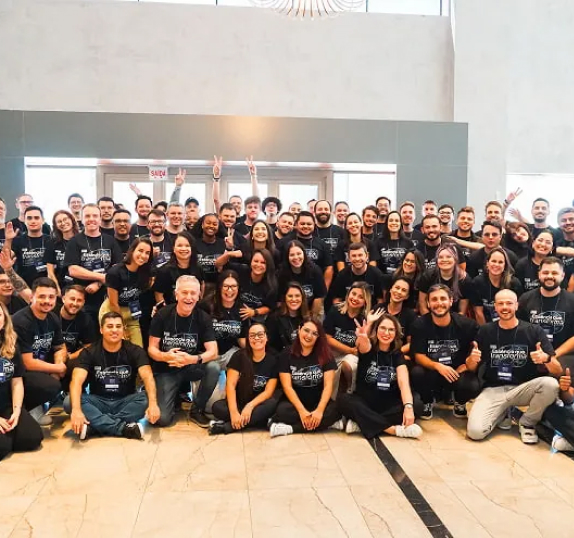 Grande equipe Seprol reunida em foto de grupo, vestindo camisetas pretas combinando, em ambiente interno